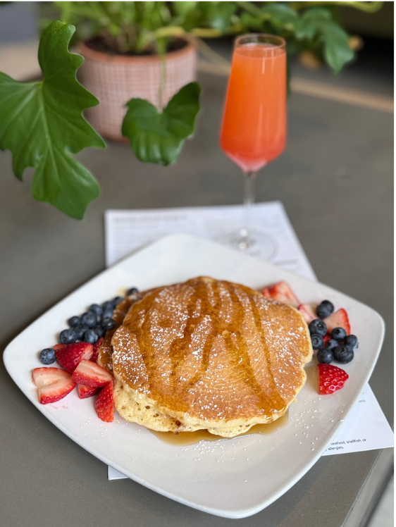 Restaurant pancakes with berries and mimosa — brunch styling