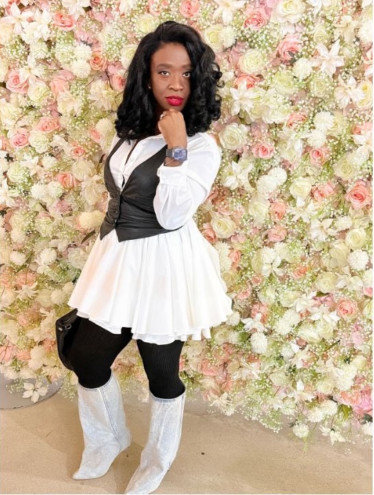 Ceva Brown standing in front of a floral wall