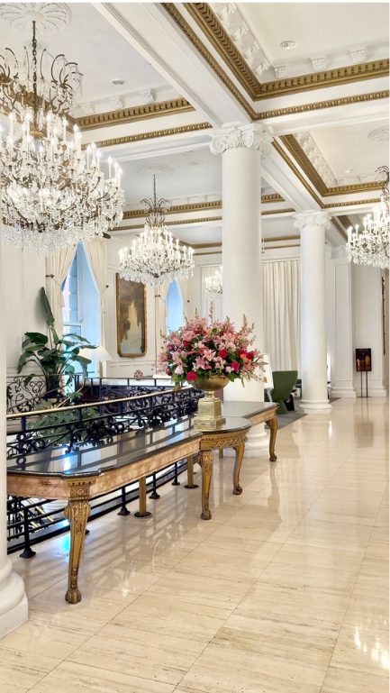 Elegant event center with chandeliers and floral arrangement